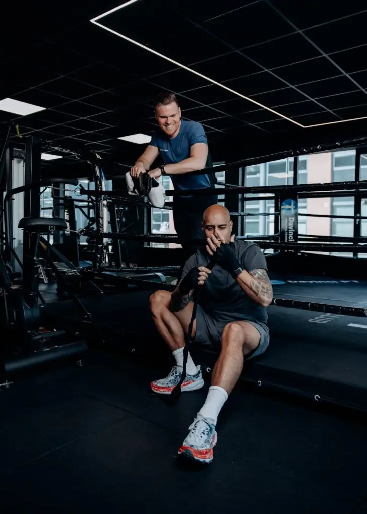 Personal trainer begeleidt een sporter op de roeimachine bij Davinci Gym